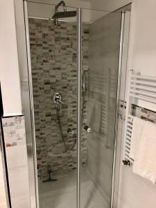 a shower in a bathroom with a stone wall at Sapphire Penthouse in Tropea