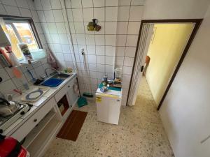a small kitchen with a sink and a refrigerator at Aruba Backpackers in Oranjestad
