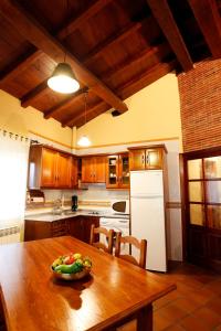 a kitchen with a wooden table with a bowl of fruit on it at Casa Rural Puerta del Sol de 3 habitaciones in Candelario