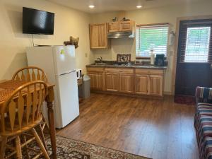 a kitchen with a white refrigerator and wooden floors at Creekside Downtown Vacation Suites, Only Adults 25 or older in Buffalo