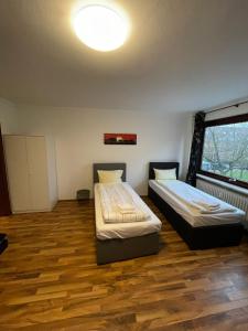 twee bedden in een kamer met een groot raam bij Studio Apartment mit Balkon in Neumünster