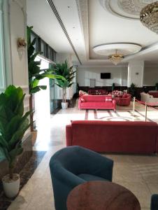فندق ايلاف الشرقية 2 Elaf Eastern Hotel 2 في سيهات: غرفة معيشة مع أرائك حمراء وأريكة