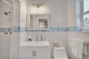 uma casa de banho branca com um lavatório e um WC em - Marine Villas Hollywood - em Hollywood