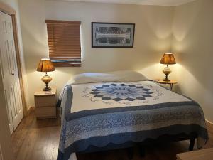 a bedroom with a bed with two lamps on tables at Creekside Downtown Vacation Suites, Only Adults 25 or older in Buffalo