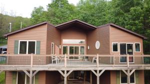 Cette maison en bois dispose d'une terrasse et d'une véranda. dans l'établissement New Mcferson Located In Alphine Lake Resort, à McComas Beach