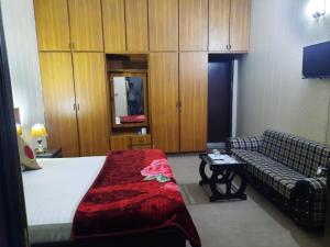 a hotel room with a bed and a couch at Hotel Royal Fort in Lahore