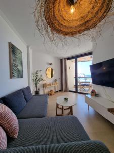 salon z niebieską kanapą i stołem w obiekcie Ola Cotillo! Ver y Sentir el Mar desde casa w mieście Cotillo