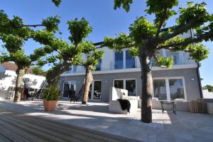 un edificio con árboles delante de él en Villa las sinas 2 - As Sinas - Pontevedra, en Villanueva de Arosa