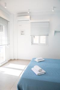 een slaapkamer met een blauw bed met 2 handdoeken erop bij Central Apartments in Stavros