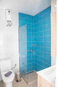 ein Bad mit einem WC und einer Dusche mit blauen Fliesen in der Unterkunft Central Apartments in Stavros