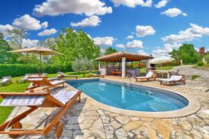 a swimming pool with patio furniture and a gazebo at House Marica 1887 in Tinjan