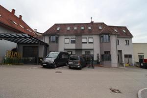 dwa pojazdy zaparkowane na parkingu przed domem w obiekcie Ferienwohnung GGM w mieście Judenburg