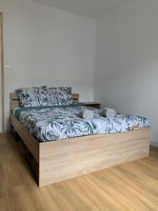 een bed met een houten frame in een kamer bij "Ancienne Mise en Bouteille" Cognac Gare in Cognac