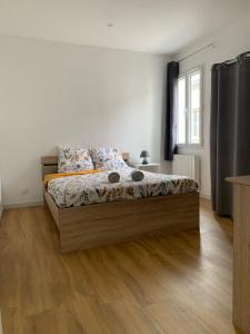 een bed in een kamer met een houten vloer bij "Ancienne Mise en Bouteille" Cognac Gare in Cognac