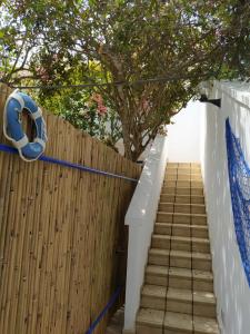 een houten hek en trap met een blauwe slang bij Casa blu in Conca Specchiulla