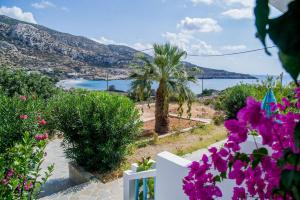 a view of the ocean from a white fence with flowers at Blue Swan Studios in Lefkos Karpathou