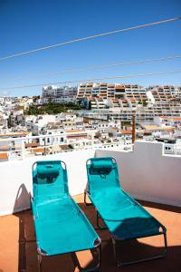 two blue chairs on a roof with a view of a city at Casa Clementina in Albufeira +3 photos