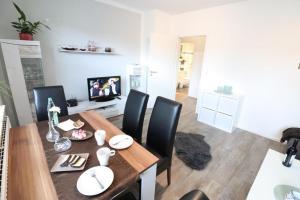 uma sala de jantar com uma mesa de madeira e cadeiras pretas em Appartementhaus-Kogge-Wohnung-3 em Cuxhaven
