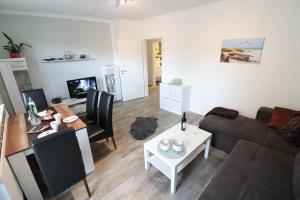 uma sala de estar com um sofá e uma mesa em Appartementhaus-Kogge-Wohnung-3 em Cuxhaven