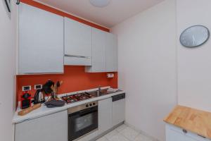 a kitchen with white cabinets and a stove top oven at Villa Ada vista lago E203 in Ghiffa