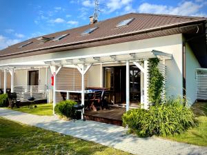 a house with a deck and a roof at Domki Letniskowe Ratownik in Sarbinowo