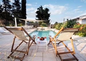 two chairs and a table next to a swimming pool at Casa 34 in Ceglie Messapica