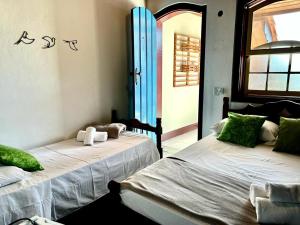Duas camas num quarto com uma janela em Pousada Marques em Paraty