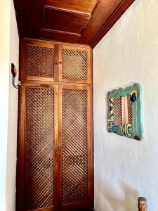 a wooden door on a wall with a sign on it at Pousada Marques in Paraty