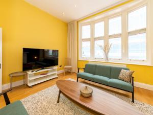 a living room with a couch and a tv at Pass the Keys Newly Renovated Stylish 2BR Flat in Town Centre in Reading