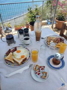 a breakfast table with eggs and toast and drinks at Villa Koutsakis in Kali Limenes