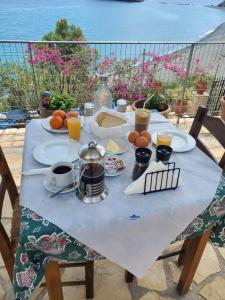 een tafel met eten en drinken en uitzicht op de oceaan bij Villa Koutsakis in Kali Limenes