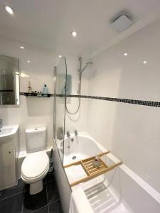 a white bathroom with a toilet and a sink at Luxury Boutique Apartment - Amazing City Location in Cambridge