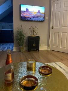 a living room with a table with two glasses and a tv at Luxury Boutique Apartment - Amazing City Location in Cambridge