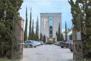 a building with cars parked in a parking lot at Class Hotel Pouso Alegre in Pouso Alegre