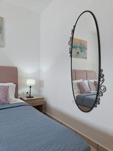 een spiegel aan een muur naast een bed bij Alkyonis Apartment Milos in Triovasálos