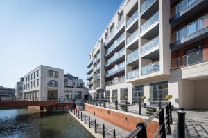 an apartment building next to a body of water at Super Vibrant 2 Bedroom With Parking in Maidenhead