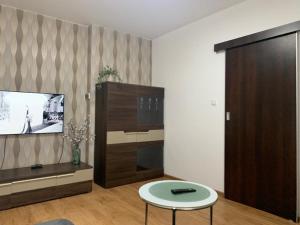a living room with a tv and a table at Mikołajki in Mikołajki