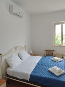 a bedroom with a large bed with a blue blanket at Villa Azzurra in Realmonte