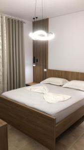 1 dormitorio con 1 cama grande con sábanas blancas en Illyrian Elite Gjiri i Lalezit en Durrës