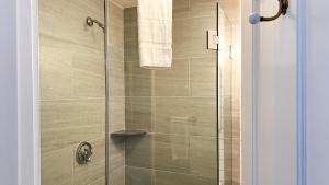 a bathroom with a shower with a glass door at Capricorn Beach House in Oak Bluffs
