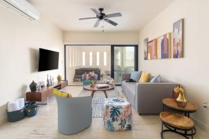 ein Wohnzimmer mit einem Sofa und einem Tisch in der Unterkunft Stylish Condo - Private Plunge Pool - 300Mbps - Rooftop in Playa del Carmen