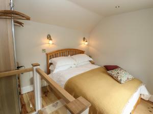 a small bedroom with a bed and a stair case at Hangmans cottage in Horncastle