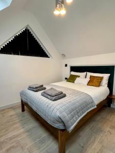 Emery Street Lodge في كامبريدج: غرفة نوم بسرير كبير عليها مناشف