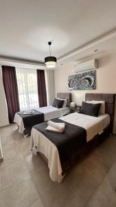 1 dormitorio con 2 camas y un cuadro en la pared en ArdorMare Hotel, en Alanya