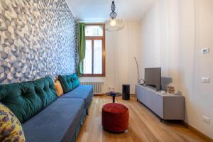 a living room with a blue couch and a tv at Rialto Bridge Lovely Apartment in Venice