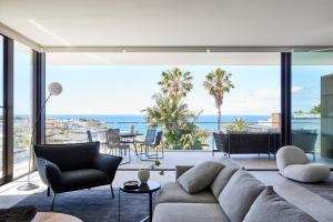 a living room with a couch and a view of the ocean at Casa Tamarama in Sydney