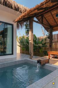una piscina frente a una casa con un banco en Waree Onsen Resort en Lamphun