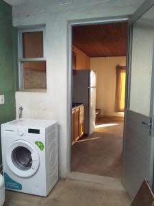 eine Küche mit einer Waschmaschine und einem Kühlschrank in der Unterkunft hospedaje vicenzo in Melo