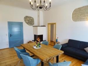 - un salon avec une table en bois et des chaises bleues dans l'établissement Gut Grasleiten, à Huglfing