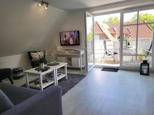 a living room with a couch and a table and a tv at Ferienwohnung "Frau Böhl" in Sankt Peter-Ording
